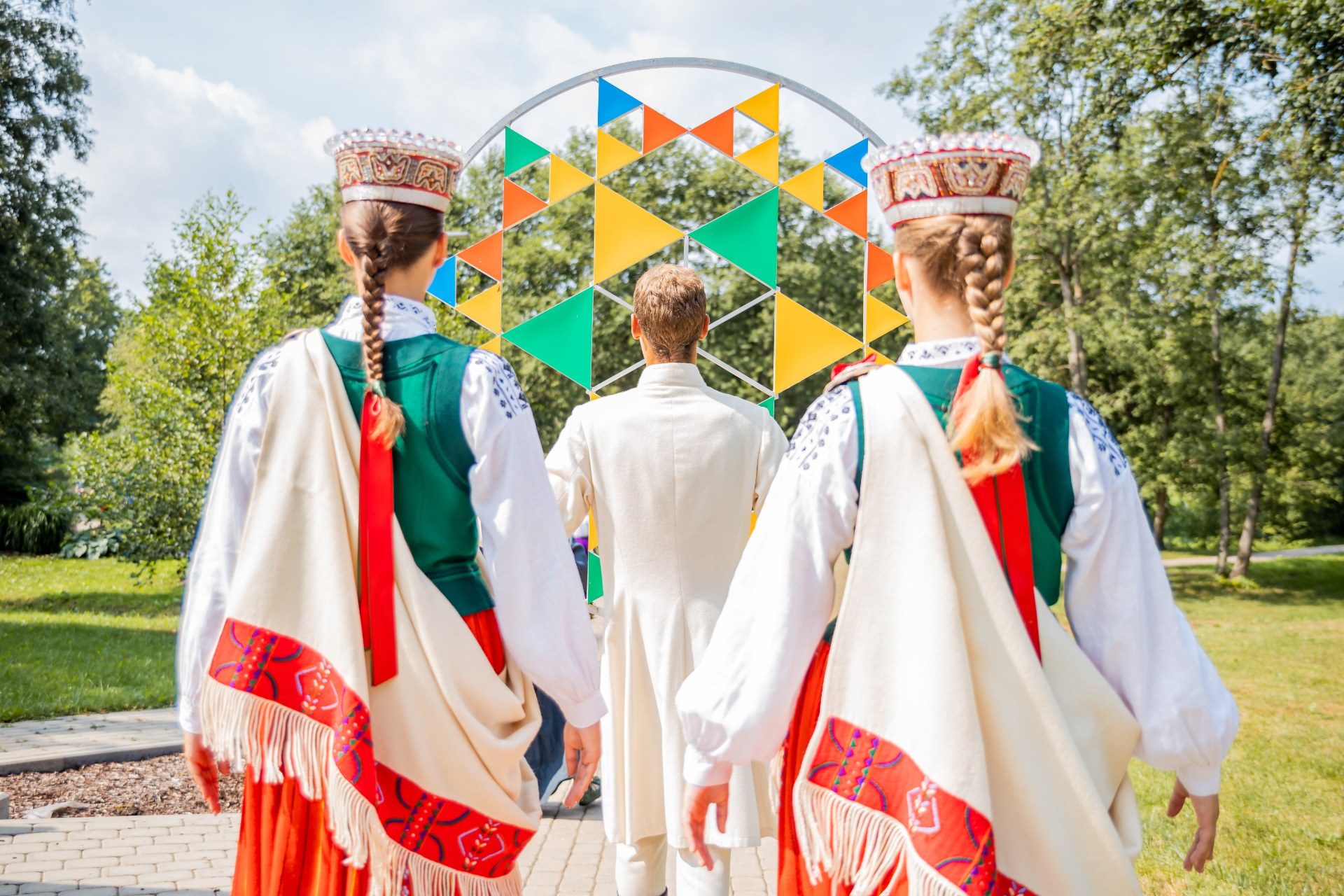 Mladí ľudia v lotyšských ľudových krojoch na Lotyšskom festivale piesní a tancov